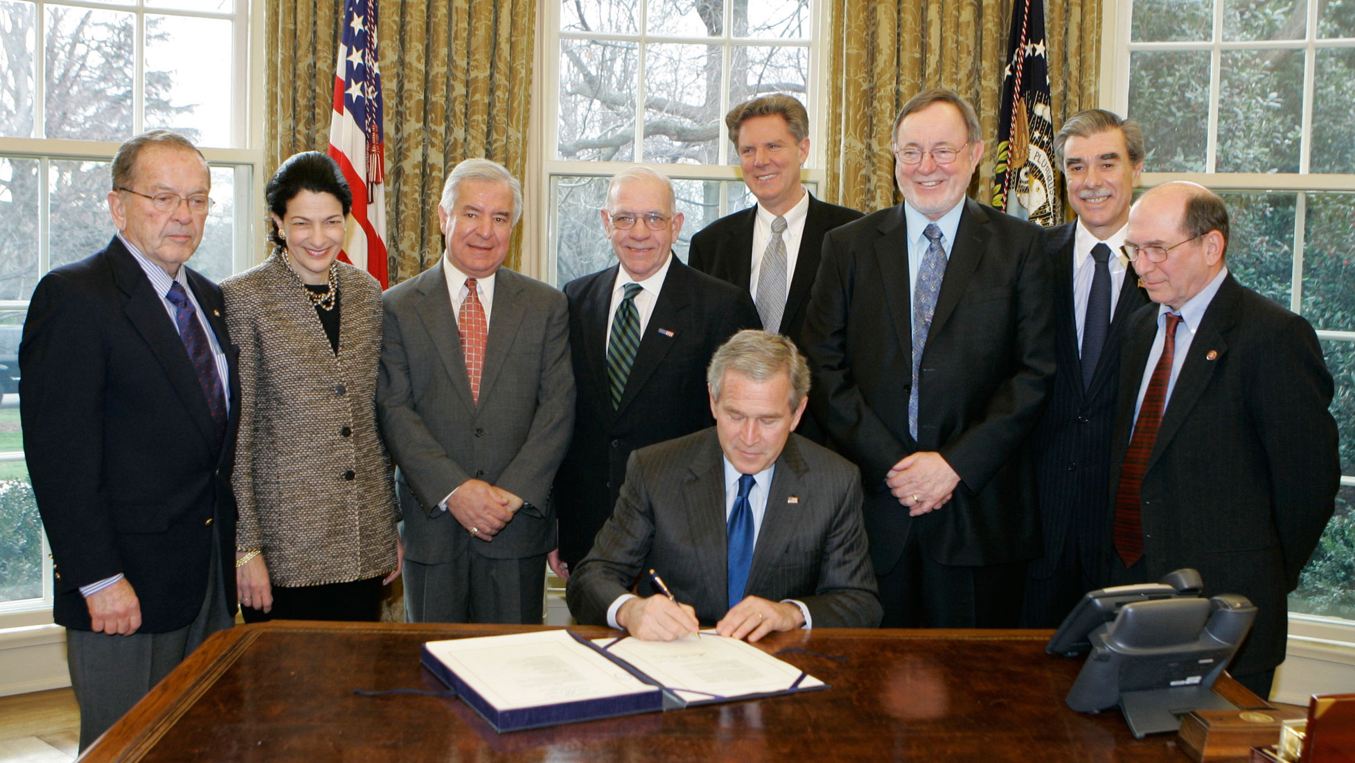 President Bush signs the Magnuson-Stevens Fishery Conservation and Management Reauthorization Act of 2006. Behind him are lawmakers from both parties.